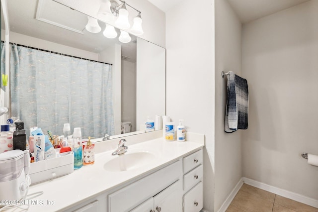 bathroom with toilet, vanity, and tile patterned flooring