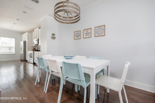 dining area featuring an inviting chandelier, crown molding, and dark hardwood / wood-style flooring