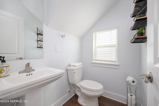 bathroom featuring hardwood / wood-style floors, vaulted ceiling, sink, and toilet