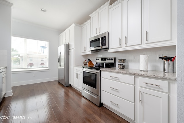 kitchen featuring light stone counters, dark hardwood / wood-style floors, stainless steel appliances, white cabinetry, and ornamental molding