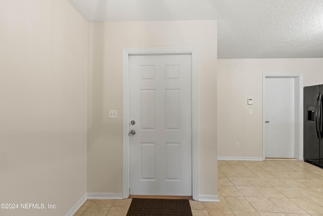 entrance foyer with a textured ceiling and light tile patterned floors