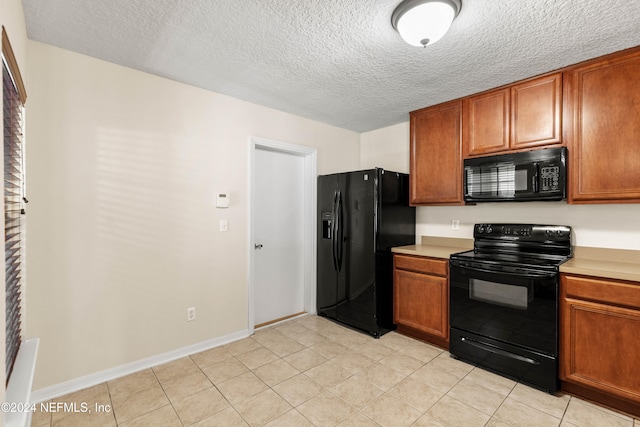 kitchen with black appliances, a textured ceiling, and light tile patterned flooring