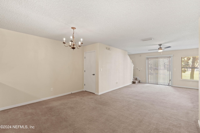 carpeted spare room featuring ceiling fan with notable chandelier and a textured ceiling