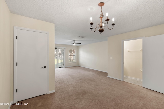 spare room with a textured ceiling, light colored carpet, and ceiling fan with notable chandelier