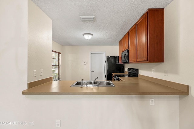 kitchen featuring black appliances, sink, and a textured ceiling