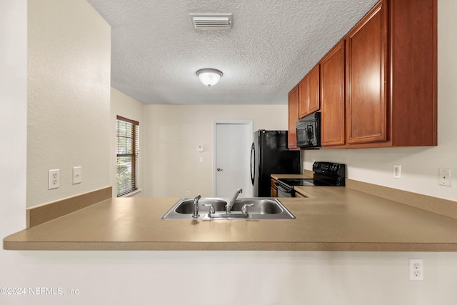 kitchen featuring black appliances, sink, and a textured ceiling