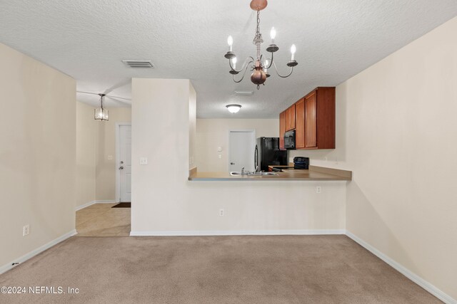 kitchen with black appliances, a textured ceiling, pendant lighting, and light colored carpet