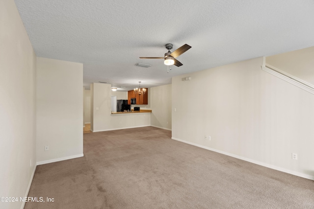 unfurnished living room with ceiling fan with notable chandelier, a textured ceiling, and carpet