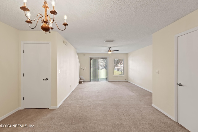 unfurnished room with a textured ceiling, light colored carpet, and ceiling fan with notable chandelier