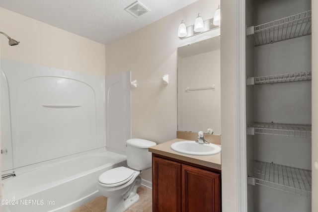 full bathroom with tile patterned flooring, a textured ceiling, vanity, shower / bath combination, and toilet