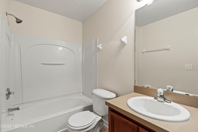 full bathroom with vanity, washtub / shower combination, a textured ceiling, and toilet