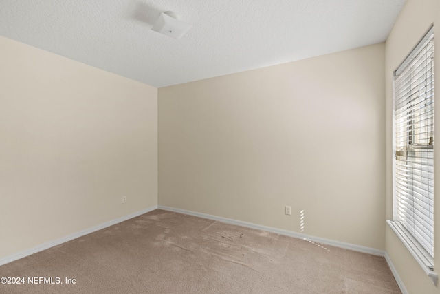 carpeted spare room with a textured ceiling