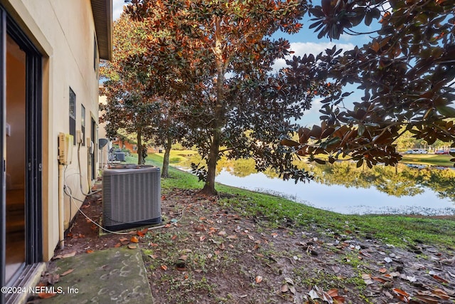 view of yard with cooling unit and a water view