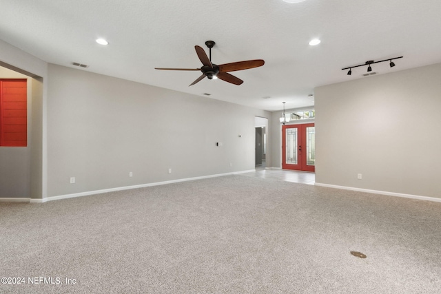 carpeted spare room with rail lighting, ceiling fan, and french doors