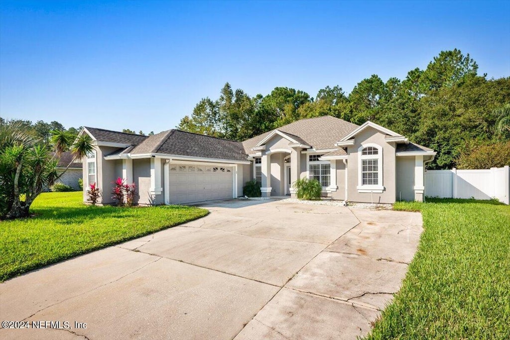 single story home with a front lawn and a garage