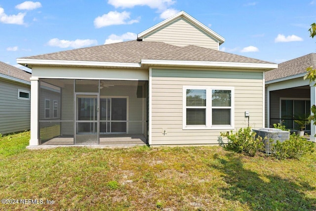 back of property featuring central air condition unit, a yard, a sunroom, and ceiling fan