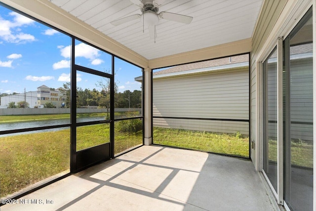 unfurnished sunroom with ceiling fan and a water view