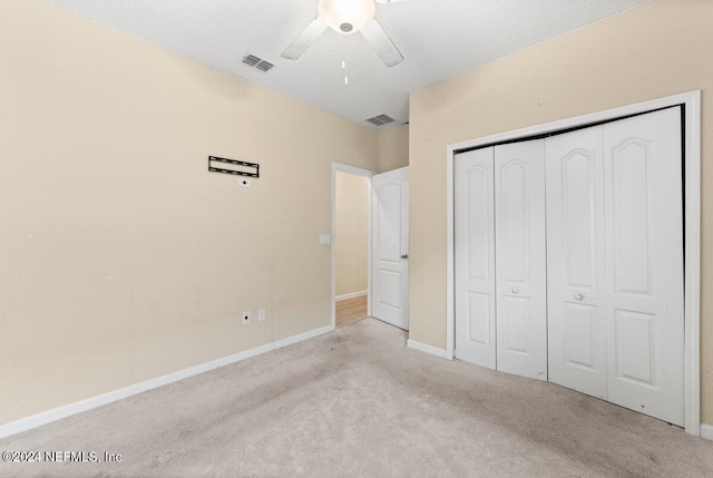 unfurnished bedroom with light carpet, ceiling fan, and a closet