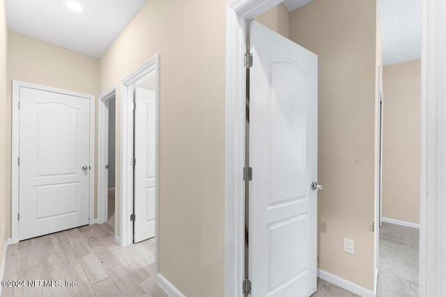 hallway with light hardwood / wood-style floors