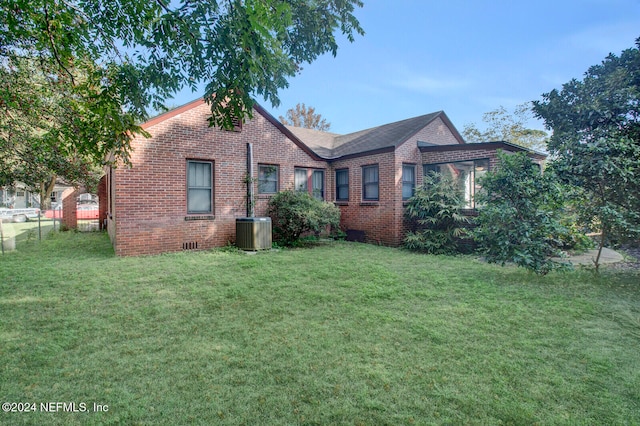 view of side of home with a yard and central air condition unit