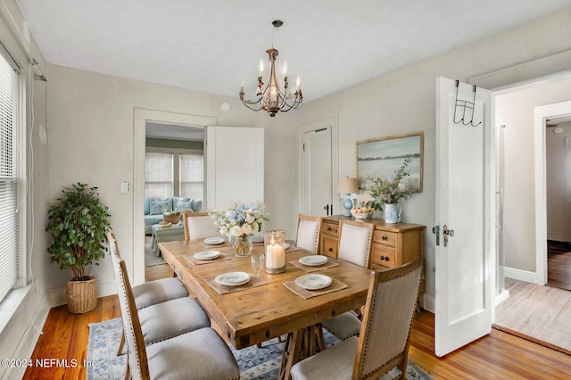 dining space featuring a notable chandelier and light hardwood / wood-style floors