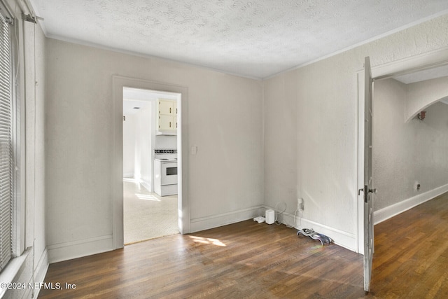 spare room with crown molding, dark wood-type flooring, and a textured ceiling