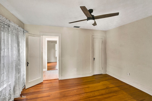 spare room with a textured ceiling, hardwood / wood-style flooring, and ceiling fan