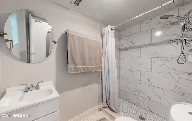 bathroom featuring toilet, vanity, walk in shower, and a textured ceiling