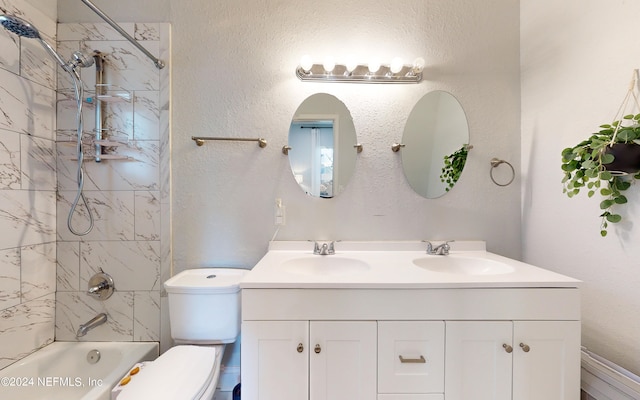 full bathroom featuring tiled shower / bath, vanity, and toilet