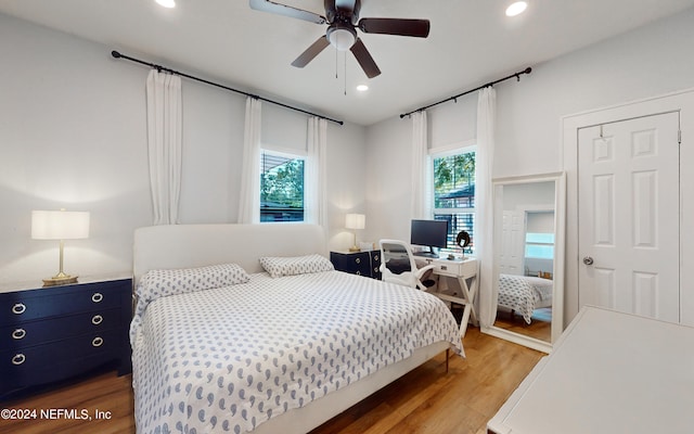 bedroom with ceiling fan, hardwood / wood-style floors, and multiple windows