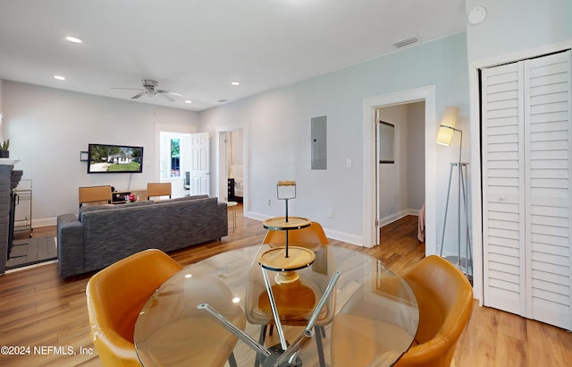 dining room featuring ceiling fan, electric panel, and light hardwood / wood-style floors