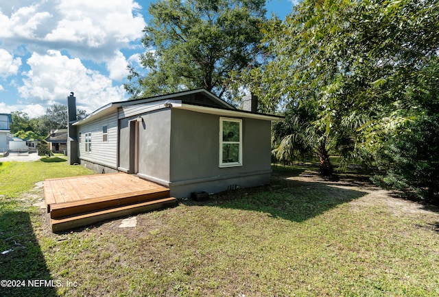 view of property exterior featuring a deck and a lawn