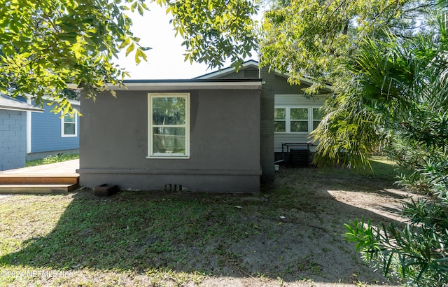 view of side of home featuring central AC unit and a wooden deck