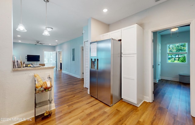 kitchen with ceiling fan, pendant lighting, light hardwood / wood-style flooring, white cabinetry, and stainless steel refrigerator with ice dispenser