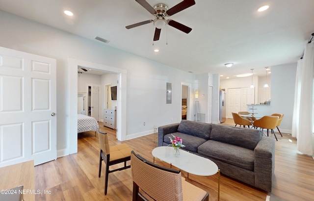 living room featuring ceiling fan and light hardwood / wood-style floors