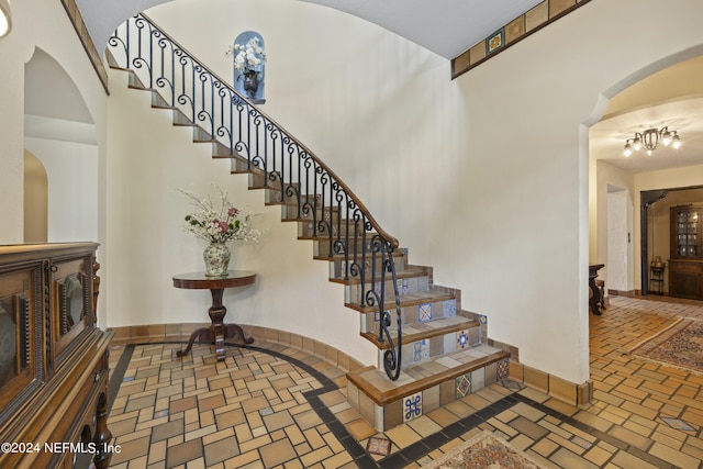 staircase with a chandelier