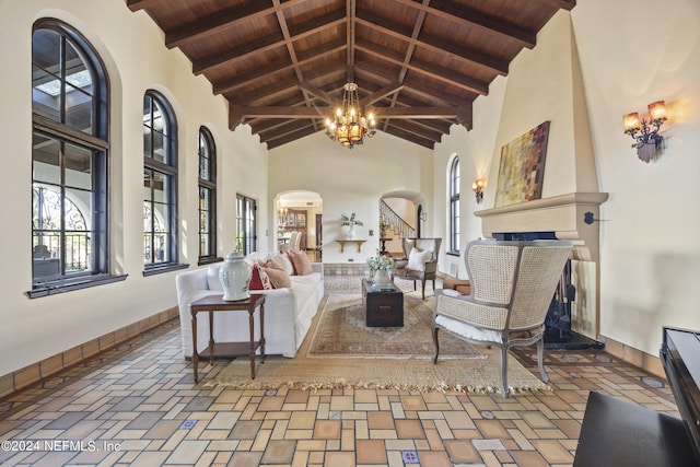 living room with beamed ceiling, a fireplace, high vaulted ceiling, and wooden ceiling