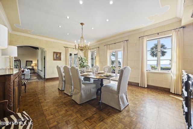 dining space with tile walls, ornamental molding, a notable chandelier, and dark parquet floors