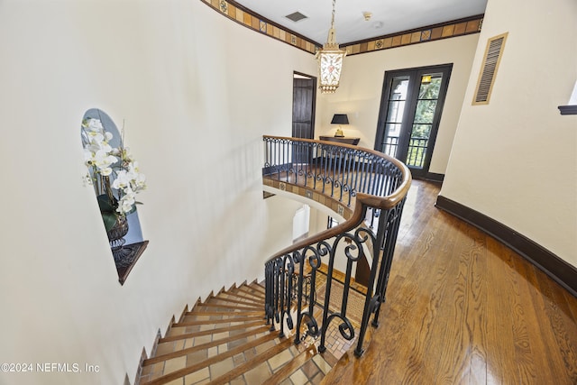 staircase featuring french doors and hardwood / wood-style floors