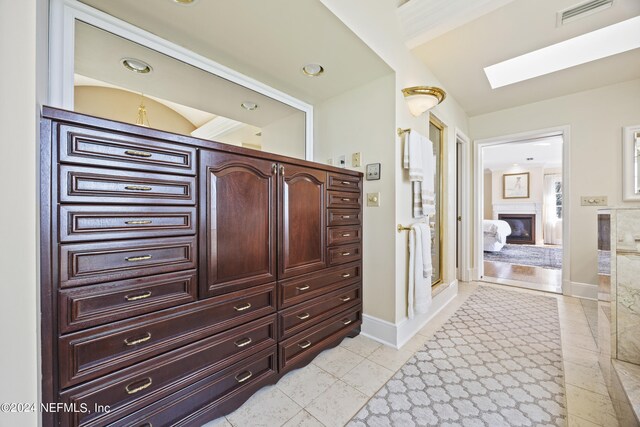 bathroom with a skylight and tile patterned flooring