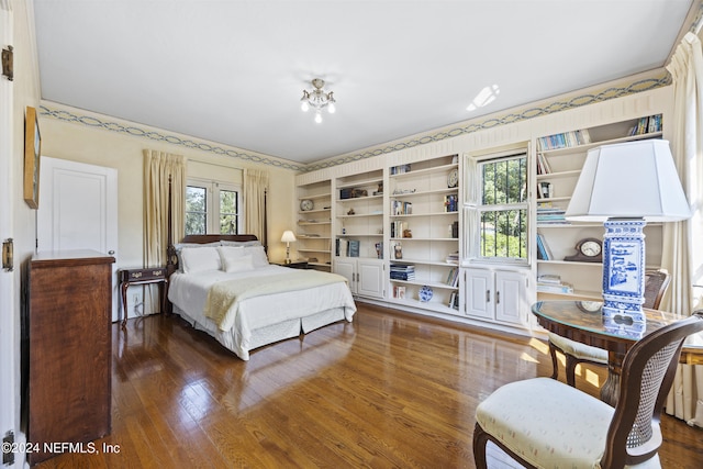 bedroom with an inviting chandelier and dark wood-type flooring