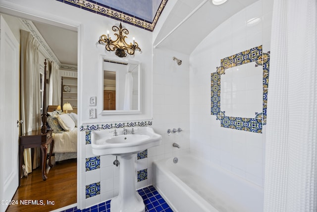 bathroom featuring tile walls, shower / bath combination with curtain, hardwood / wood-style flooring, and lofted ceiling