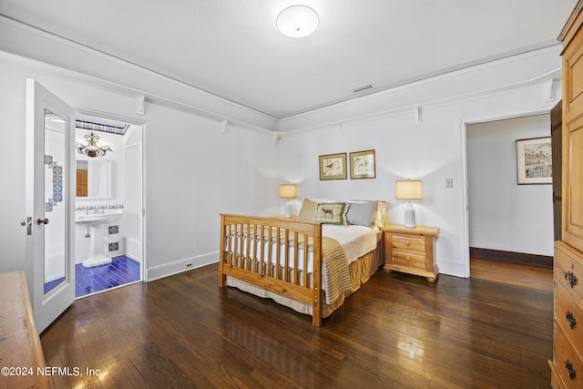 bedroom featuring ensuite bathroom and dark wood-type flooring