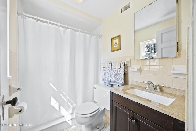 bathroom with vanity, toilet, tile walls, and walk in shower