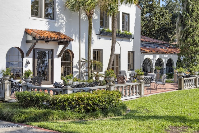 back of house featuring a patio area and a lawn