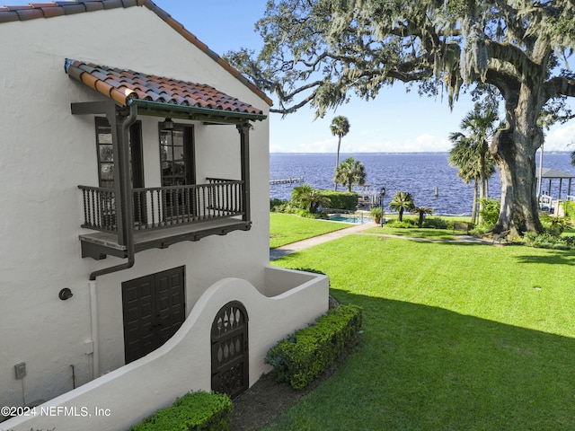 view of yard with a balcony and a water view