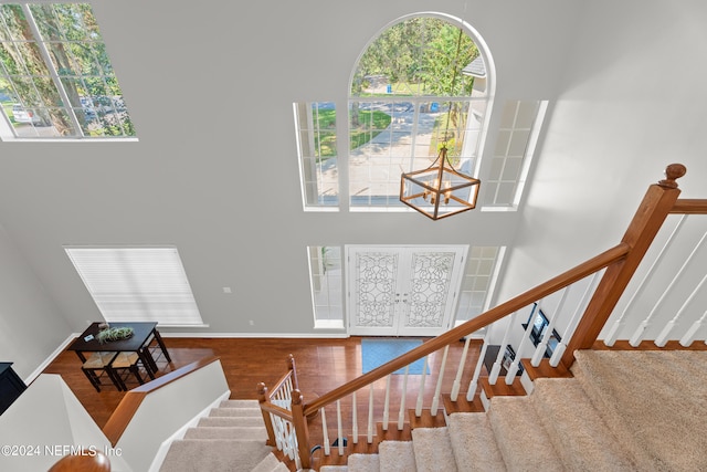13601 Emerald Cove Ct, Jacksonville, FL 32225 - stairway with a high ceiling, wood finished floors, french doors, baseboards, and a notable chandelier