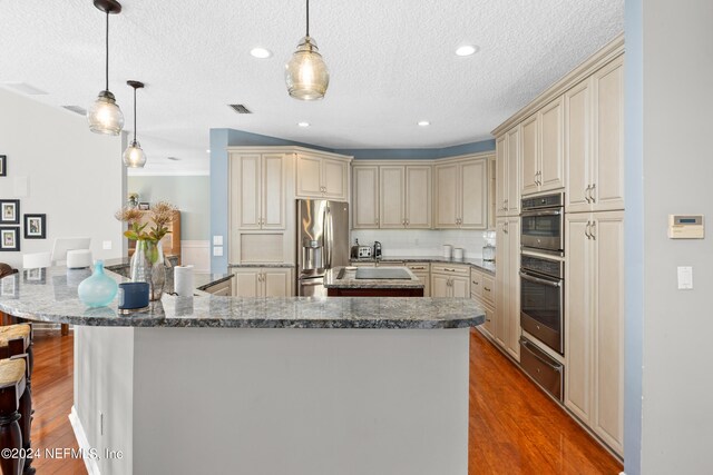 13601 Emerald Cove Ct, Jacksonville, FL 32225 - kitchen with a warming drawer, cream cabinetry, appliances with stainless steel finishes, and an island with sink