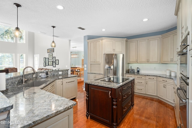 13601 Emerald Cove Ct, Jacksonville, FL 32225 - kitchen with an island with sink, stainless steel appliances, wood finished floors, a sink, and cream cabinets
