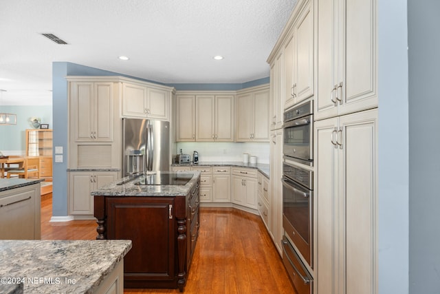 13601 Emerald Cove Ct, Jacksonville, FL 32225 - kitchen with light stone countertops, wood finished floors, stainless steel fridge, and a warming drawer